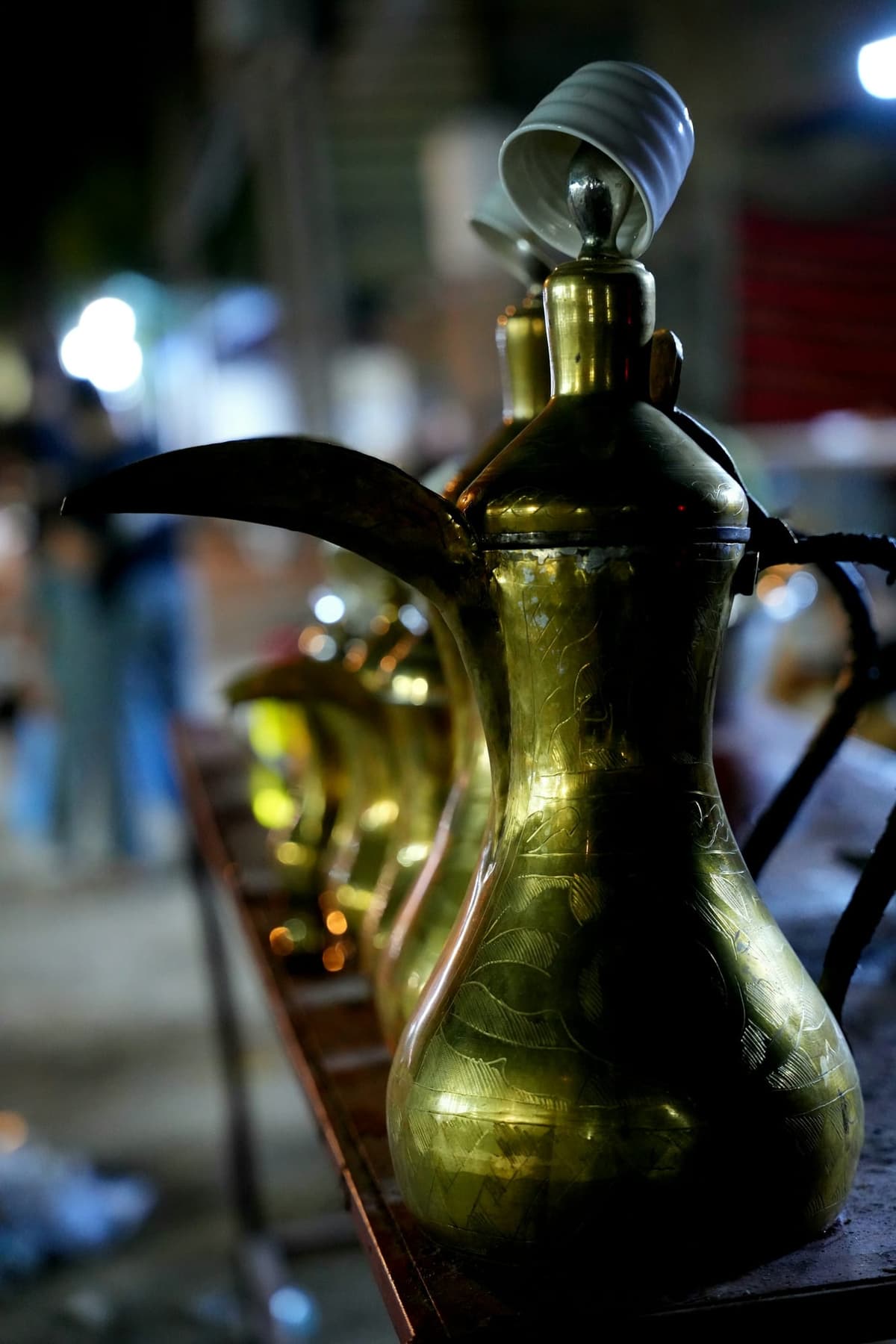 Mosiężny dzbanek do arabskiej kawy na stole w wieczornym świetle